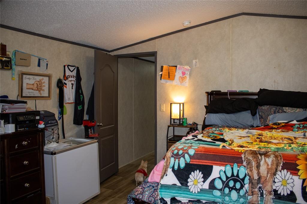145 Firefly Drive Springtown, TX 76082 - Photo 13 of 16 a bedroom with a bed and a dresser in it