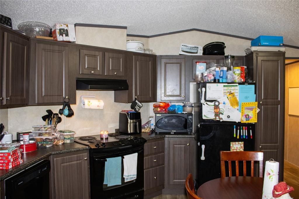 145 Firefly Drive Springtown, TX 76082 - Photo 10 of 16 a kitchen with stainless steel appliances granite countertop a stove top oven a dining table and chairs with wooden floor