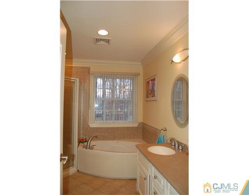 12 Ramsey Road Edison, NJ 08820 - Photo 14 of 25 a bathroom with a granite countertop tub sink and mirror