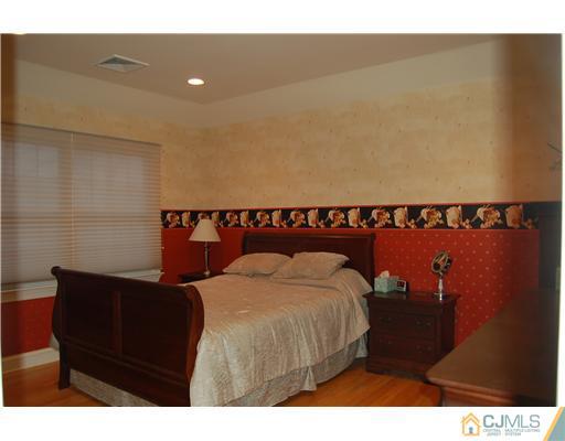 12 Ramsey Road Edison, NJ 08820 - Photo 18 of 25 a bed sitting in a bedroom next to a lamp