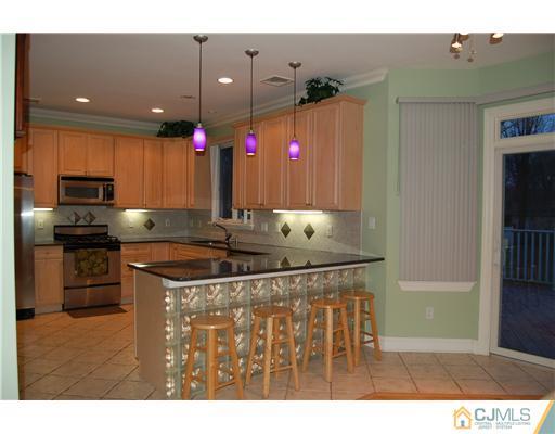 12 Ramsey Road Edison, NJ 08820 - Photo 7 of 25 a kitchen with kitchen island granite countertop a sink stainless steel appliances and cabinets