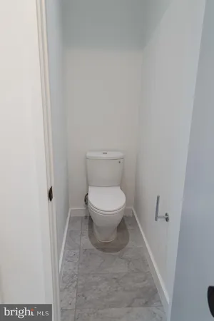 a white toilet sitting next to a shower
