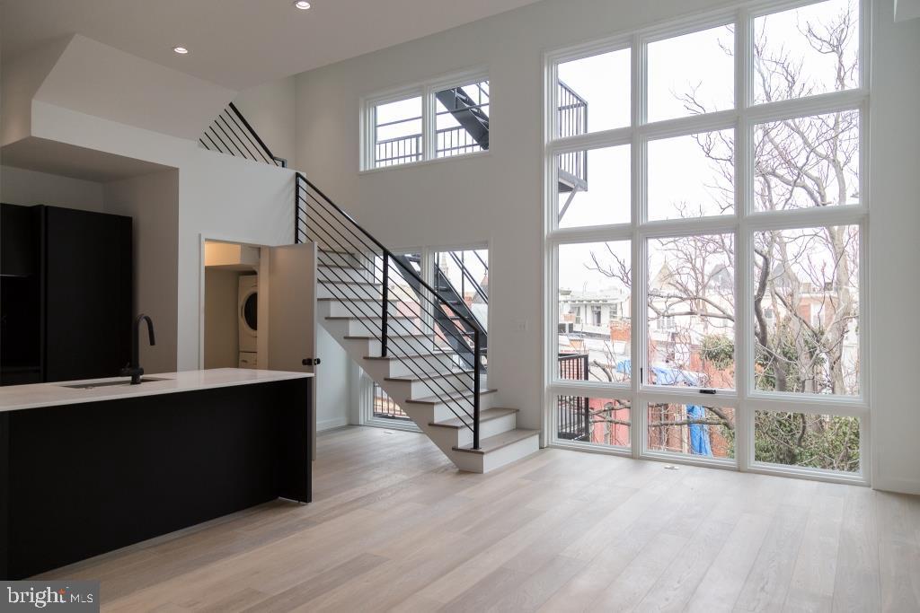 1443 Euclid Street Northwest, Unit 8 Washington, DC 20009 - Photo 2 of 20 a view of an empty room with wooden floor and a window