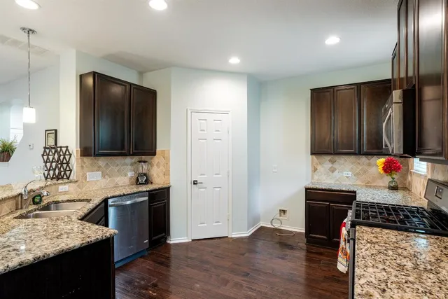 an empty room with wooden floor and a ceiling fan