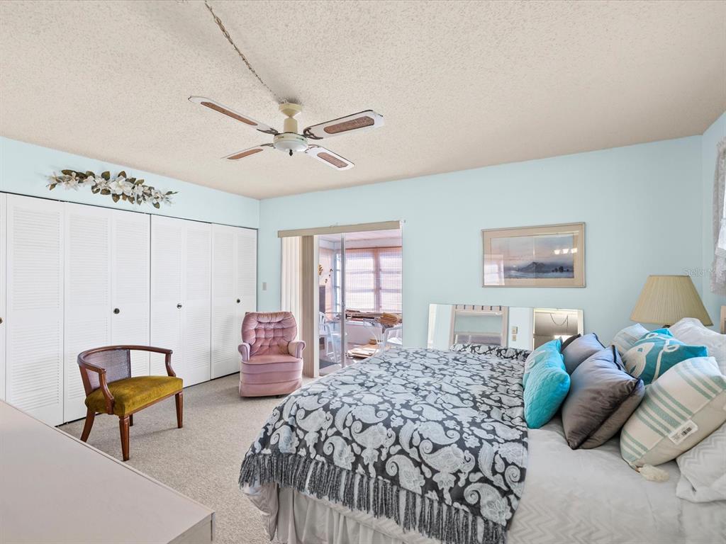 11735 Boynton Lane, Unit 11735 New Port Richey, FL 34654 - Photo 14 of 25 a bedroom with a bed and a chandelier