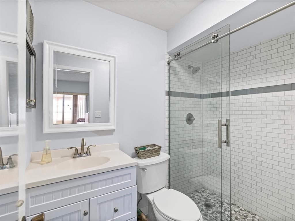 11735 Boynton Lane, Unit 11735 New Port Richey, FL 34654 - Photo 16 of 25 a bathroom with a sink a toilet and shower