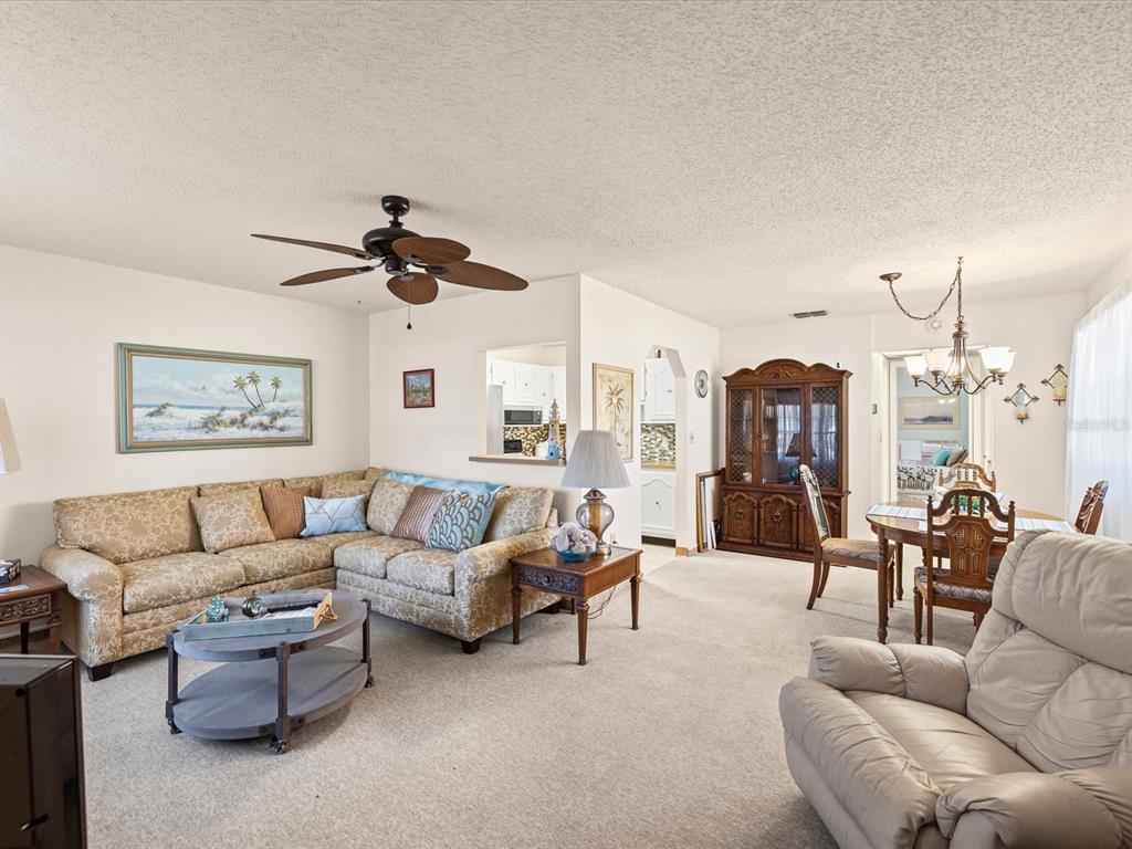 11735 Boynton Lane, Unit 11735 New Port Richey, FL 34654 - Photo 5 of 25 a living room with furniture and a chandelier