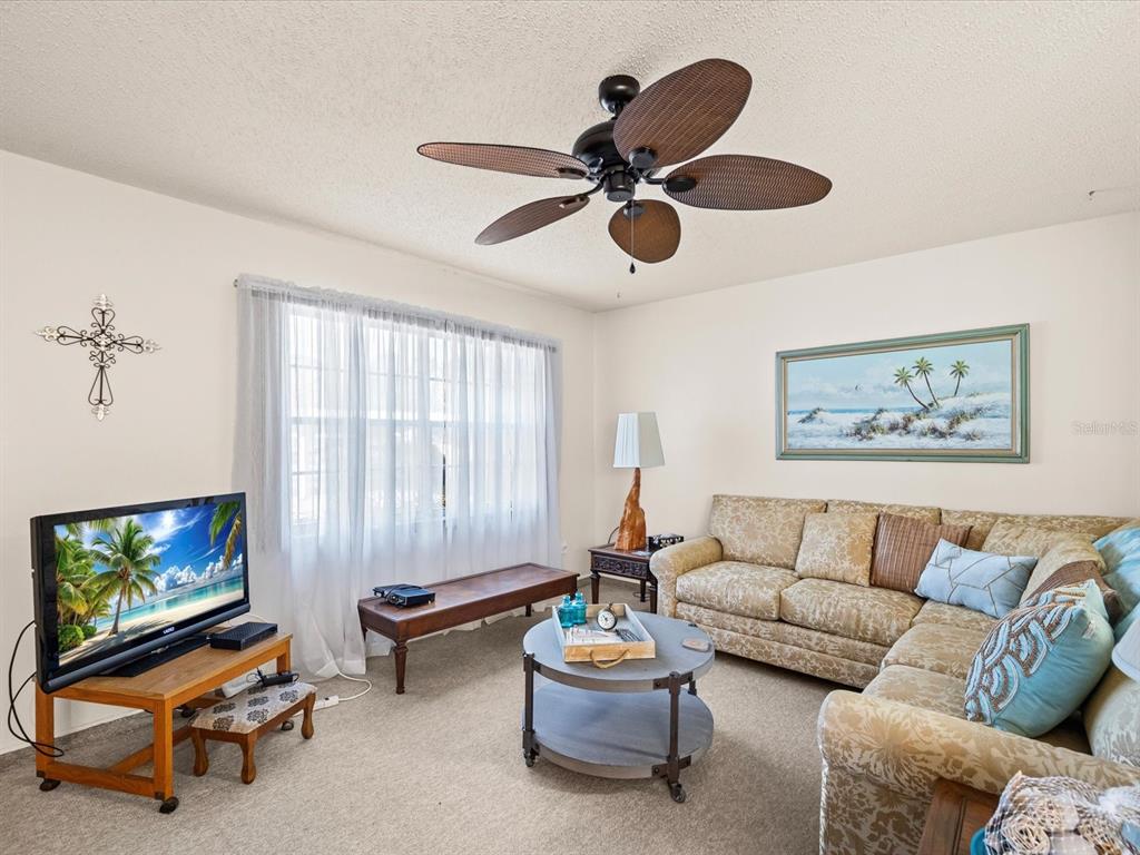 11735 Boynton Lane, Unit 11735 New Port Richey, FL 34654 - Photo 7 of 25 a living room with furniture and a flat screen tv