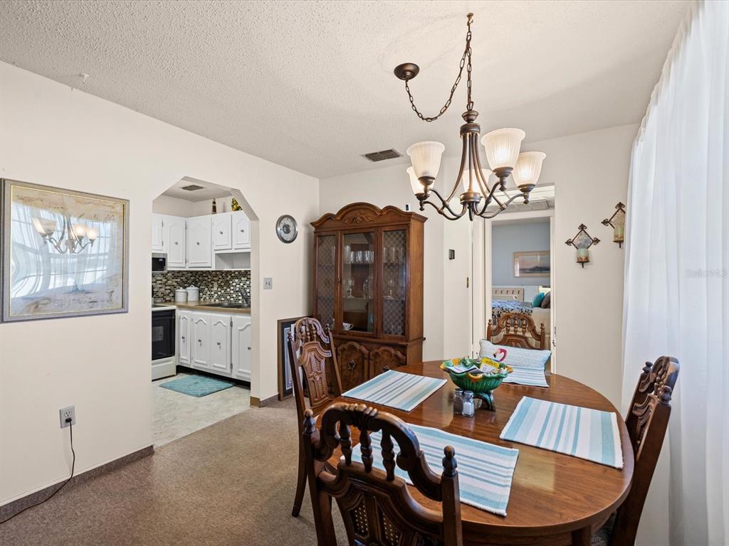 11735 Boynton Lane, Unit 11735 New Port Richey, FL 34654 - Photo 8 of 25 a view of a dining room with furniture and chandelier