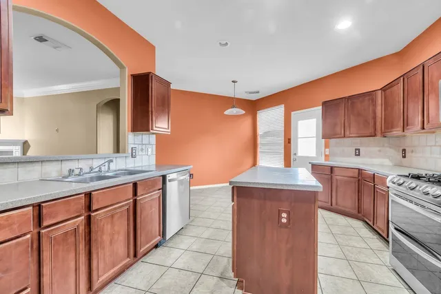 a kitchen with stainless steel appliances granite countertop a stove sink and cabinets