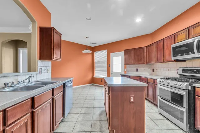 a kitchen with stainless steel appliances granite countertop a sink stove and cabinets