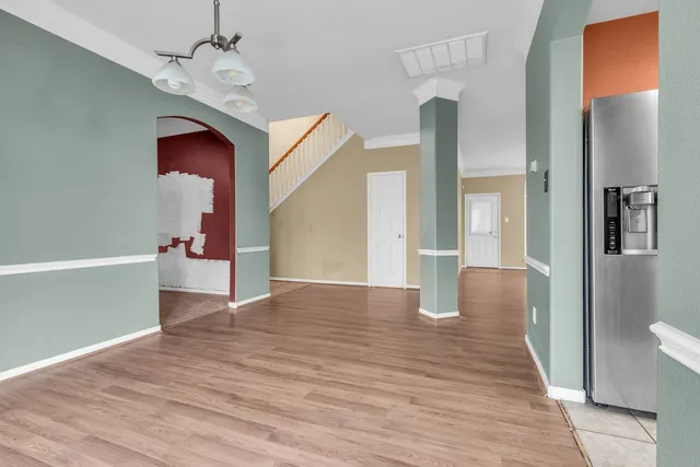 a view of a hallway with wooden floor and staircase