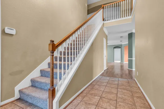 a view of staircase with railing and white walls
