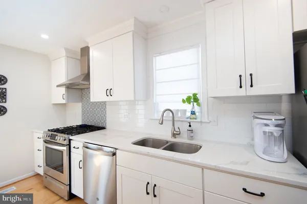 a kitchen with stainless steel appliances a sink a stove and cabinets