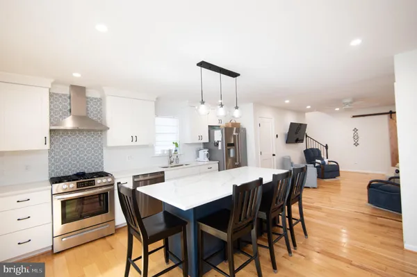a kitchen with stainless steel appliances a stove a table and chairs