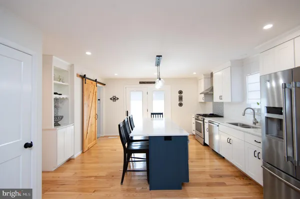 a large kitchen with a table and refrigerator