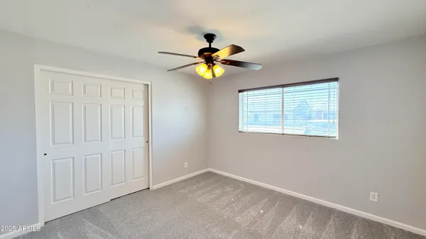 a a room with ceiling fan and window