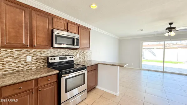 a kitchen with granite countertop a stove a sink and a microwave