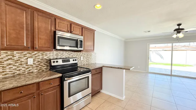 a kitchen with granite countertop a stove a sink and a microwave