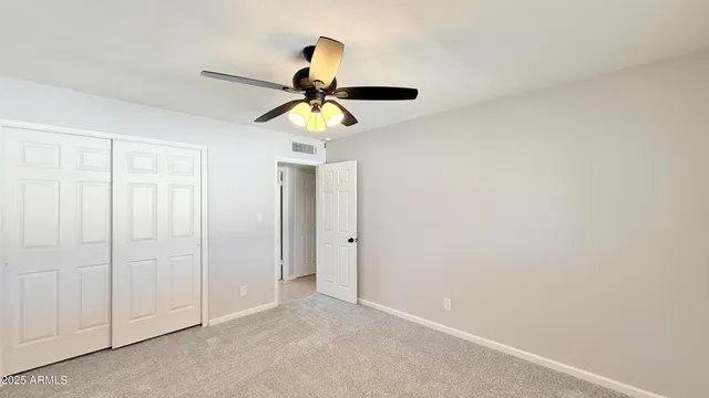 an empty room with a window and a fan