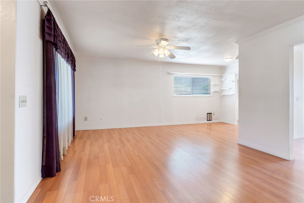 9130 Duncan Avenue Riverside, CA 92503 - Photo 5 of 34 an empty room with wooden floor chandelier fan and windows