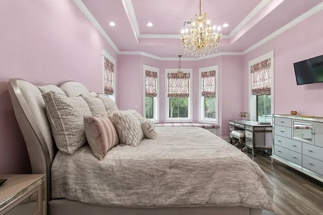 a bedroom with a large bed and a chandelier