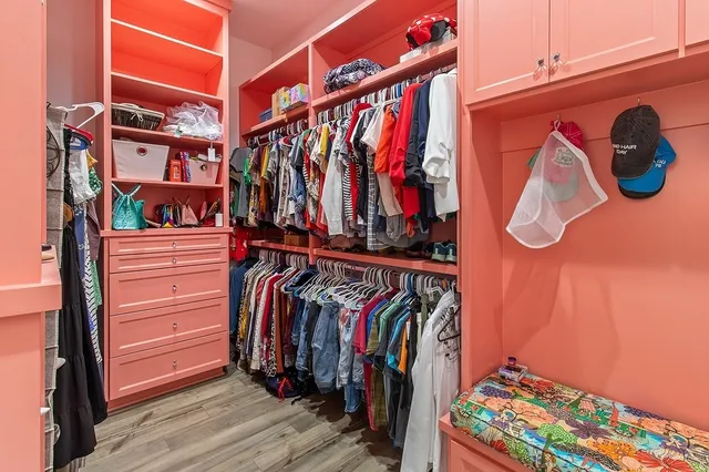 a view of walk in closet with clothes and shoes