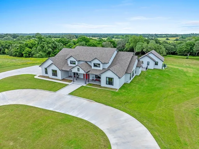 an aerial view of a house with swimming pool garden view and a yard