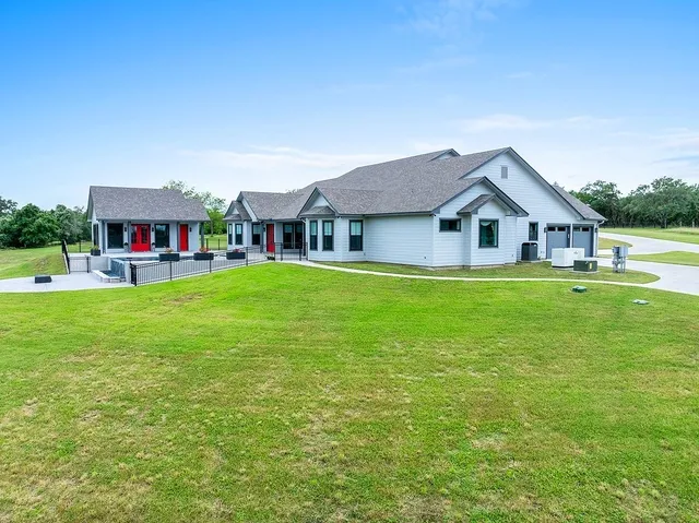 a view of a house with a big yard and potted plants