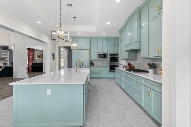 a kitchen with kitchen island a sink stainless steel appliances and refrigerator