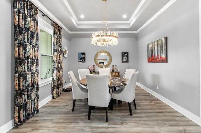 a view of a dining room with furniture wooden floor and chandelier