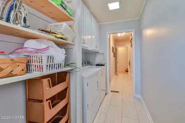 a kitchen with stainless steel appliances granite countertop a stove top oven a sink dishwasher and white cabinets with wooden floor