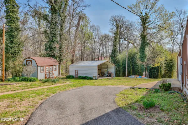 a front view of a house with a yard and trees