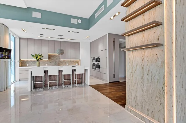 a dining room with stainless steel appliances kitchen island granite countertop furniture and a refrigerator