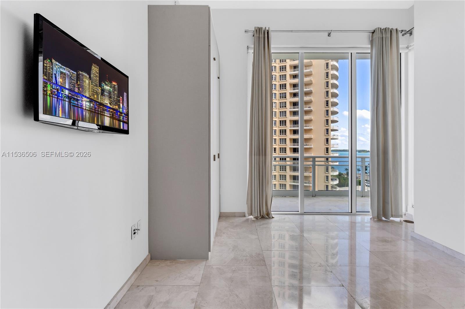 900 Brickell Key Boulevard, Unit 1002 Miami, FL 33131 - Photo 43 of 87 a view of a room with wooden floor and windows