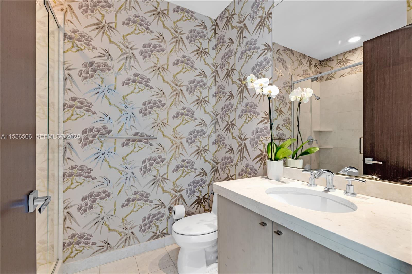 900 Brickell Key Boulevard, Unit 1002 Miami, FL 33131 - Photo 46 of 87 a bathroom with a sink and mirror with toilet