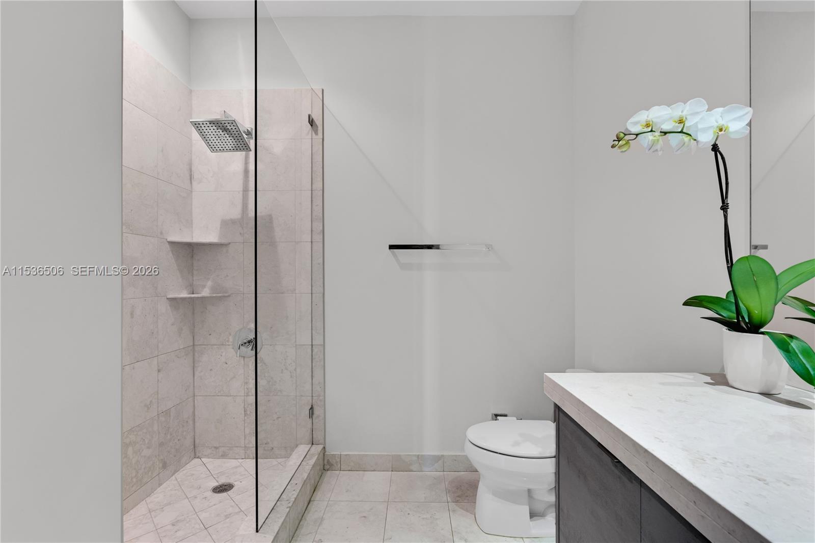 900 Brickell Key Boulevard, Unit 1002 Miami, FL 33131 - Photo 67 of 87 a bathroom with a shower a toilet and a sink