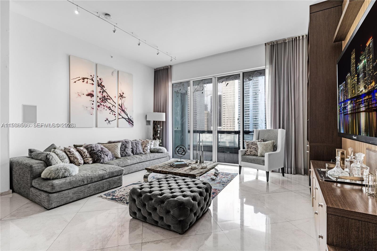 900 Brickell Key Boulevard, Unit 1002 Miami, FL 33131 - Photo 79 of 87 a living room with furniture large window and a flat screen tv