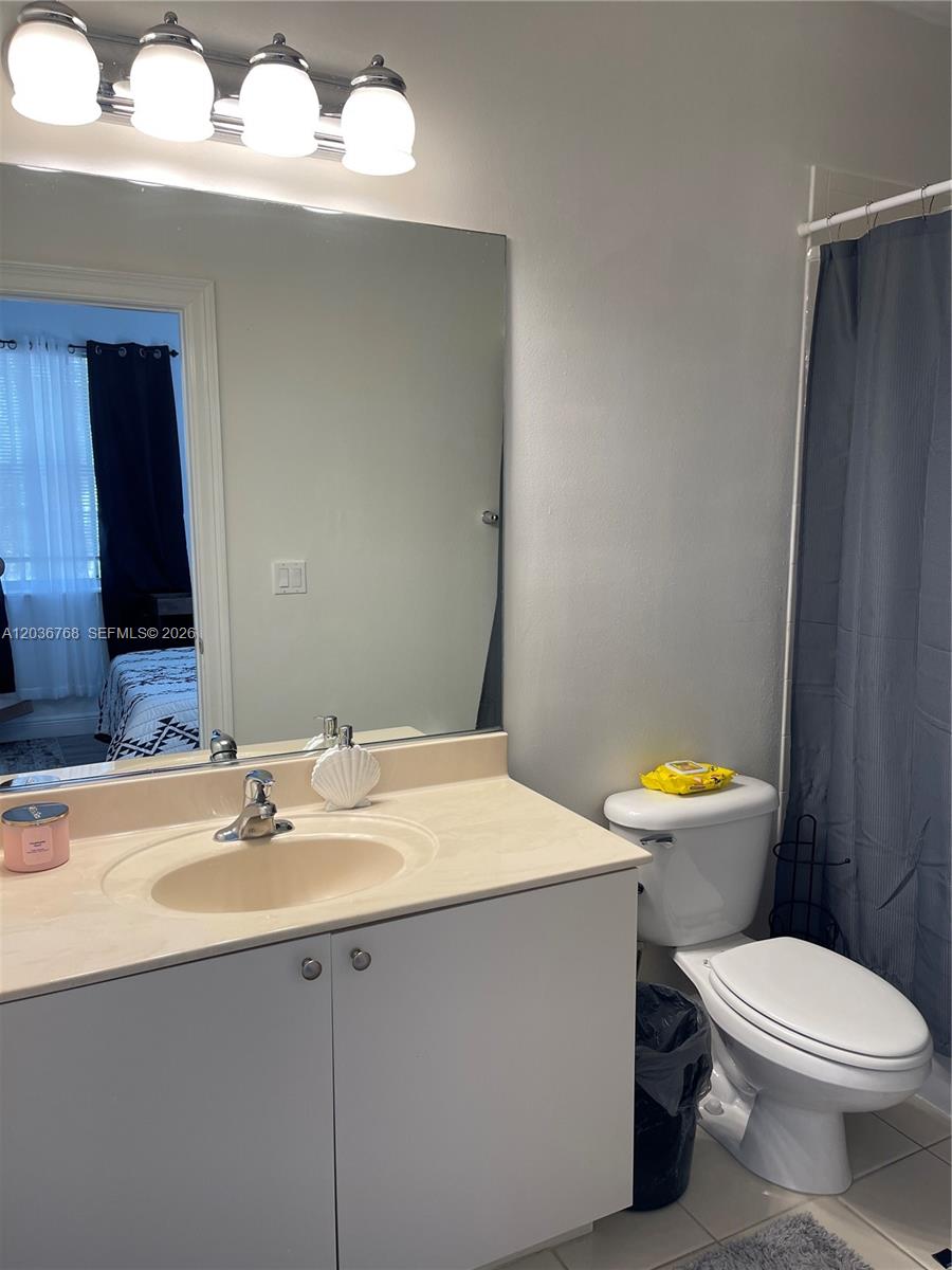 2432 Southwest 99th Way Miramar, FL 33025 - Photo 8 of 17 a bathroom with a sink a toilet a mirror and vanity