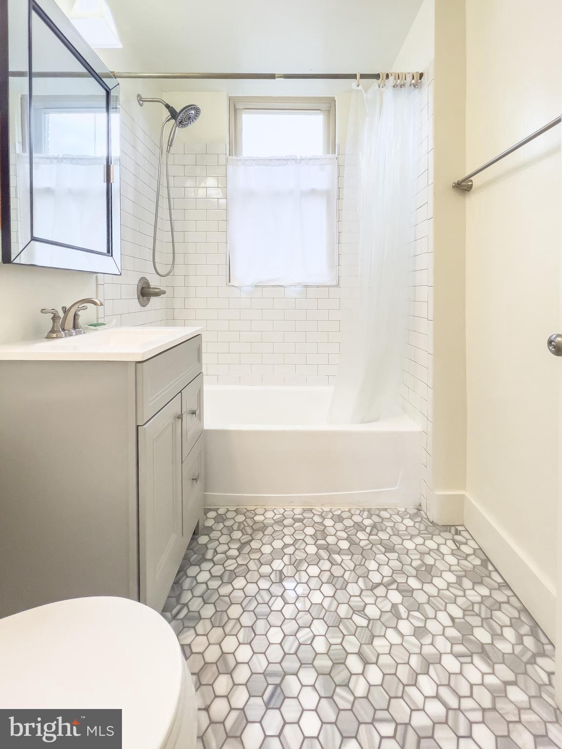 1725 Lanier Place Northwest, Unit 9C Washington, DC 20009 - Photo 12 of 18 a bathroom with a sink a toilet a shower a vanity and a mirror