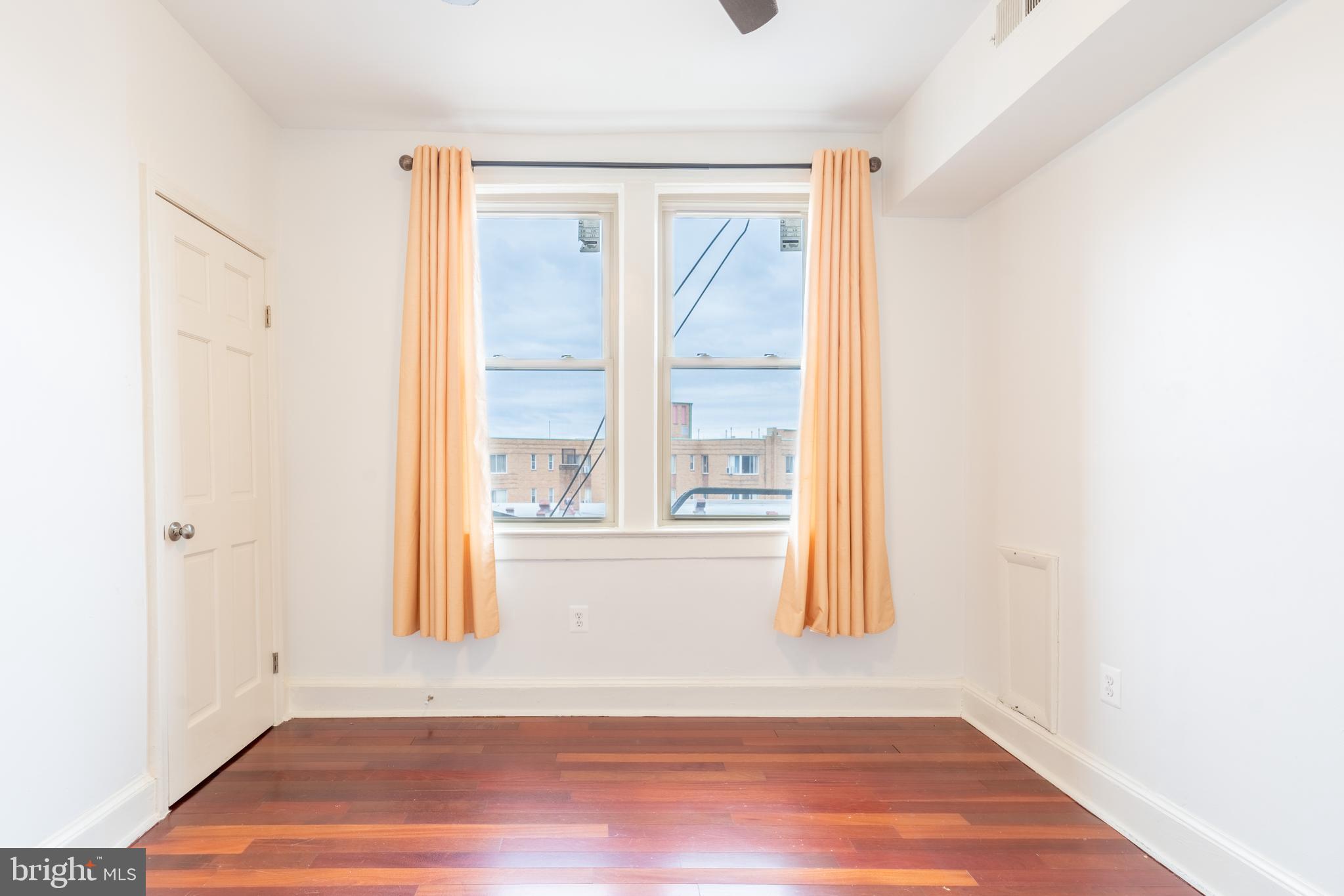 1725 Lanier Place Northwest, Unit 9C Washington, DC 20009 - Photo 17 of 18 a view of empty room with wooden floor and fan