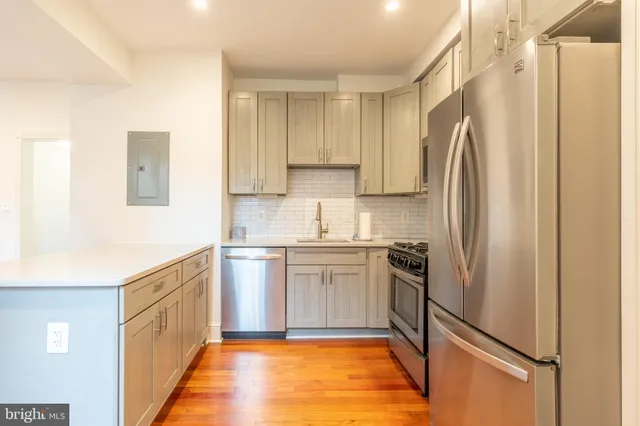 a kitchen with stainless steel appliances a refrigerator sink and microwave