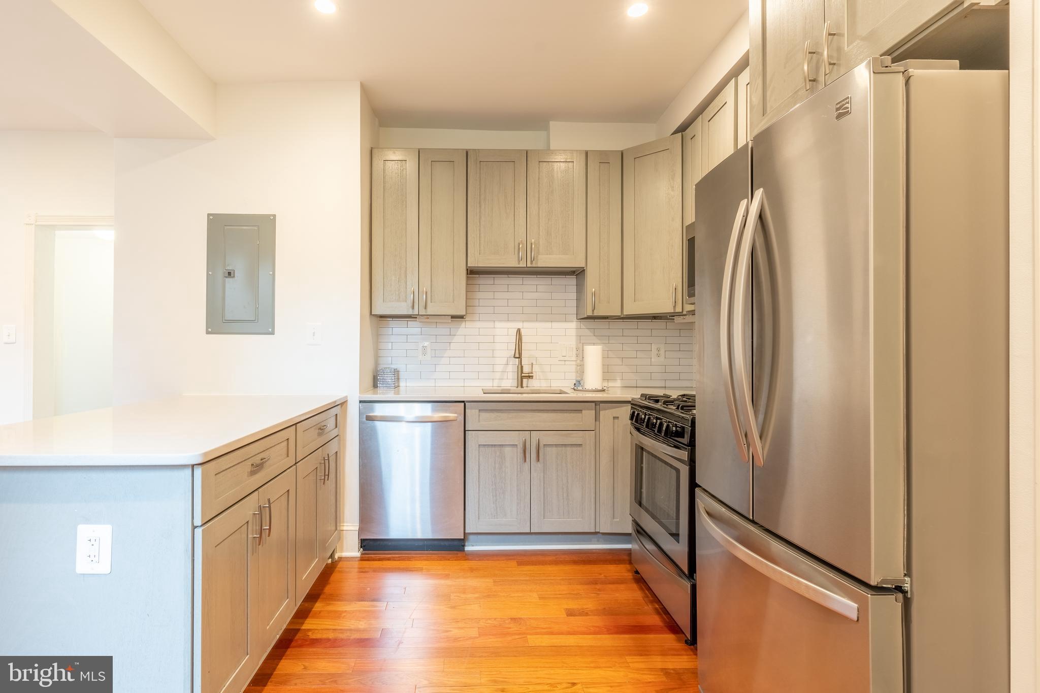 1725 Lanier Place Northwest, Unit 9C Washington, DC 20009 - Photo 4 of 18 a kitchen with stainless steel appliances a refrigerator sink and microwave