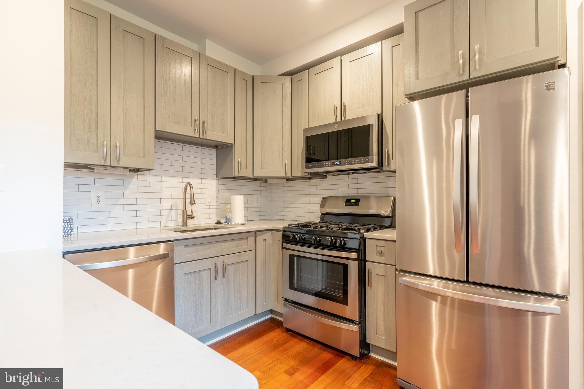 1725 Lanier Place Northwest, Unit 9C Washington, DC 20009 - Photo 7 of 18 a kitchen with stainless steel appliances granite countertop a refrigerator sink and stove