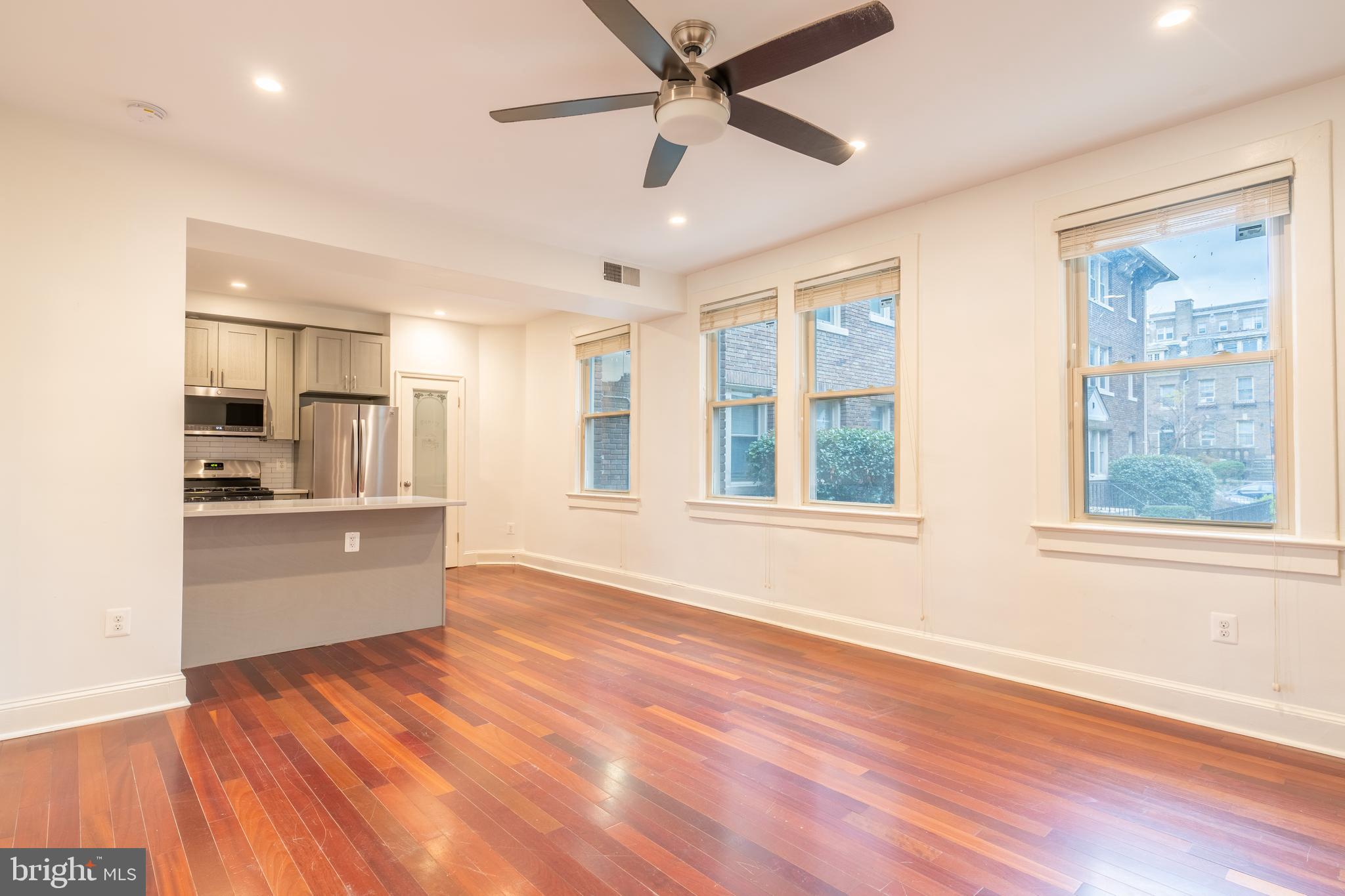 1725 Lanier Place Northwest, Unit 9C Washington, DC 20009 - Photo 8 of 18 a large kitchen with granite countertop a large window and stainless steel appliances