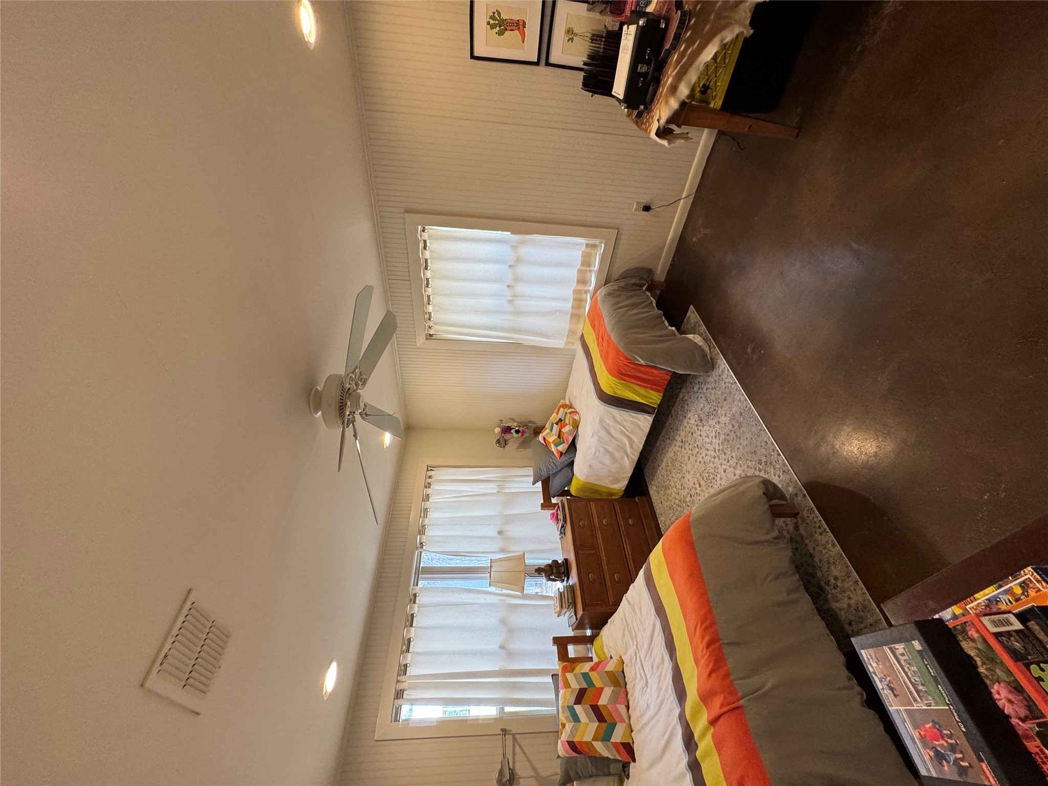 12501 Fitzhugh Road Austin, TX 78736 - Photo 19 of 40 Well-lit sleeping quarters with a ceiling fan, offering a comfortable and serene retreat.