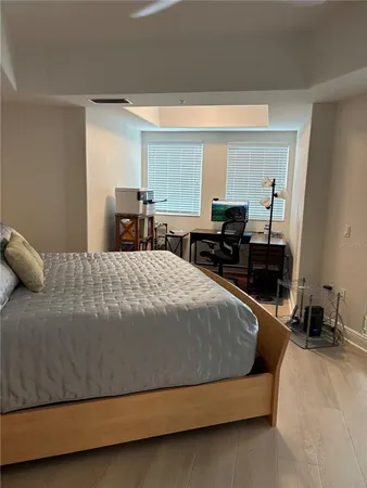 a bedroom with a bed and wooden floor