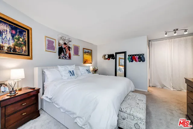 a bedroom with a bed and a painting on the wall