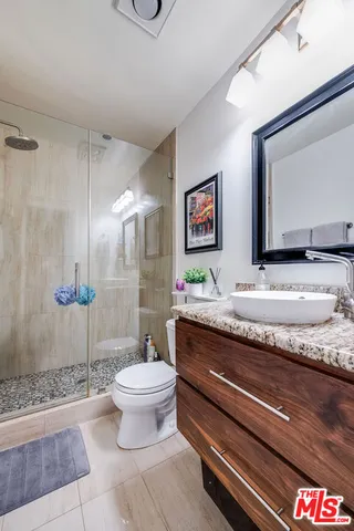 a bathroom with a granite countertop toilet sink and mirror