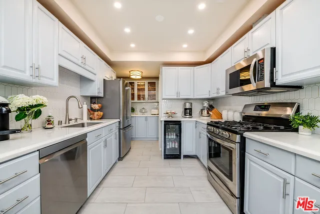 a kitchen with stainless steel appliances granite countertop a sink and stove top oven